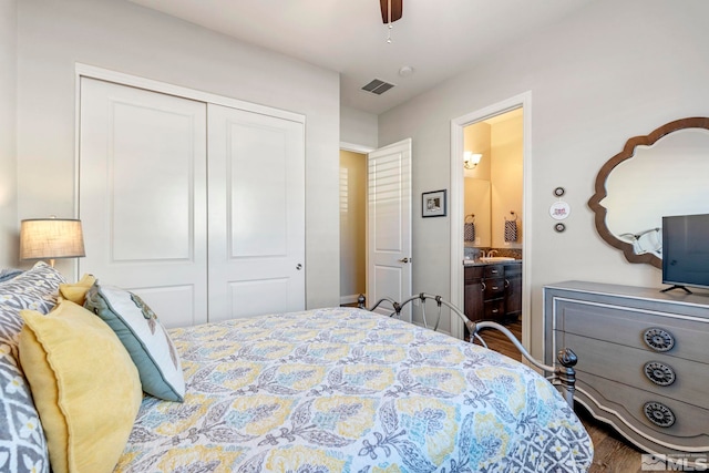 bedroom with ensuite bathroom, a closet, hardwood / wood-style flooring, and ceiling fan