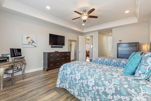 bedroom featuring hardwood / wood-style flooring, ceiling fan, a raised ceiling, and crown molding