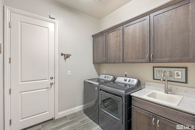 washroom with washer and clothes dryer, cabinets, and sink