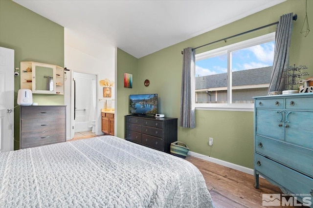 bedroom featuring ensuite bath and light hardwood / wood-style flooring