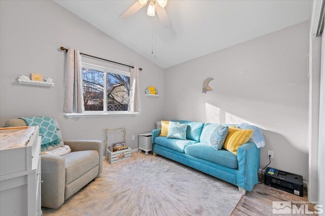 living room with ceiling fan, wood-type flooring, and lofted ceiling