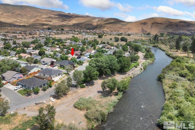 drone / aerial view featuring a water and mountain view