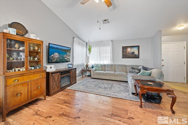 living room with ceiling fan, light wood-type flooring, and lofted ceiling