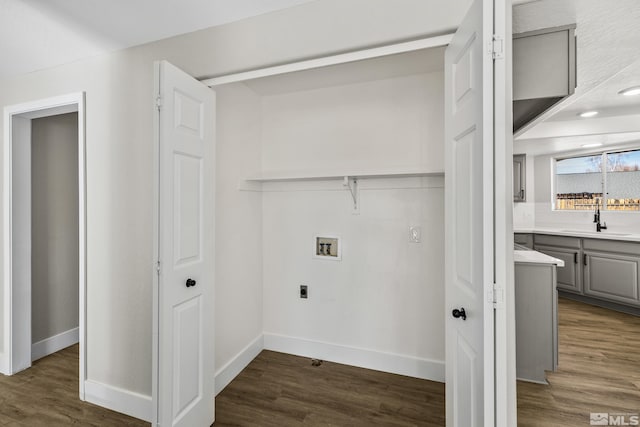 laundry room with electric dryer hookup, hookup for a washing machine, dark hardwood / wood-style floors, and sink