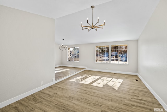 unfurnished room with light wood-type flooring and a chandelier