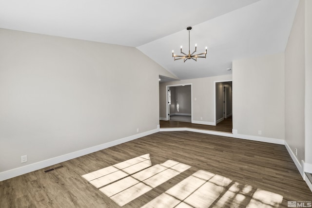 unfurnished room with hardwood / wood-style floors, lofted ceiling, and a notable chandelier