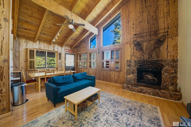 living room with wood ceiling, beam ceiling, hardwood / wood-style flooring, high vaulted ceiling, and a fireplace