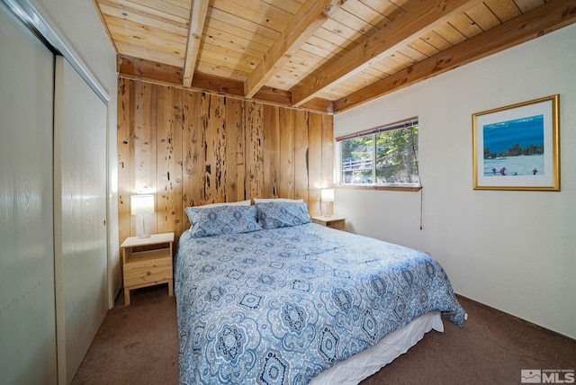 carpeted bedroom featuring beamed ceiling, a closet, wooden ceiling, and wood walls