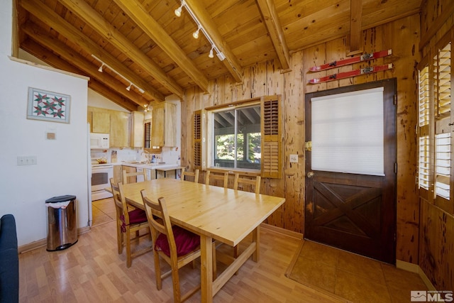 dining space with wood walls, sink, rail lighting, and wooden ceiling