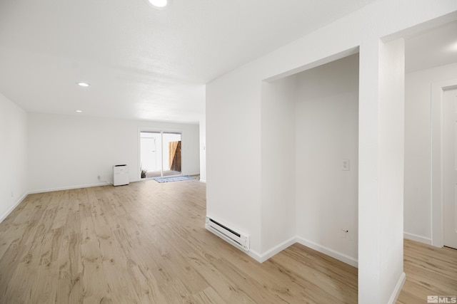 empty room with light hardwood / wood-style flooring and a baseboard radiator