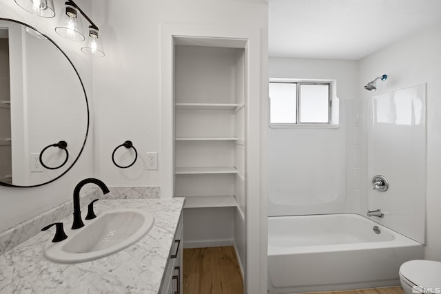 full bathroom featuring shower / bathing tub combination, hardwood / wood-style floors, vanity, and toilet