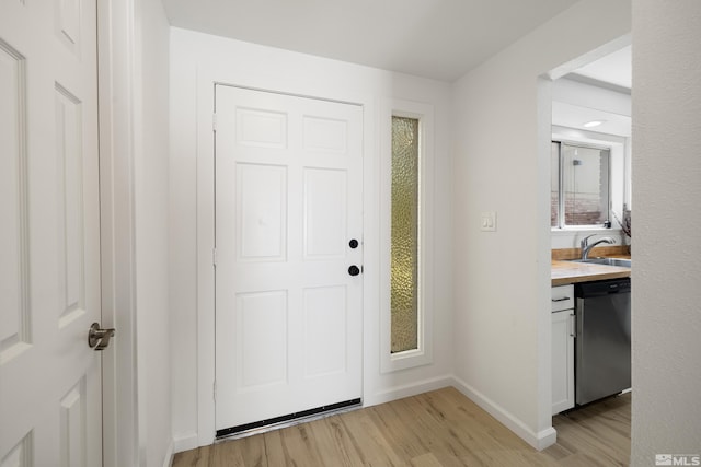 doorway to outside featuring sink and light hardwood / wood-style flooring