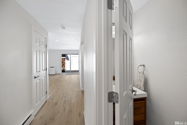 hallway featuring light wood-type flooring and a baseboard radiator