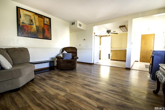 living room featuring ceiling fan and dark hardwood / wood-style floors