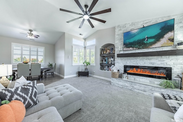 carpeted living room with a fireplace, ceiling fan, and lofted ceiling