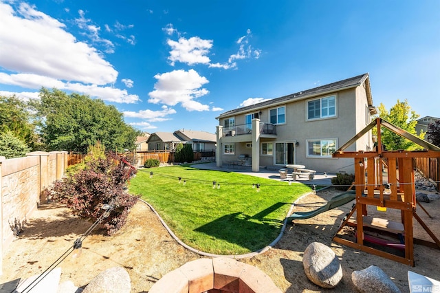 back of house with a lawn, a balcony, a playground, and a patio