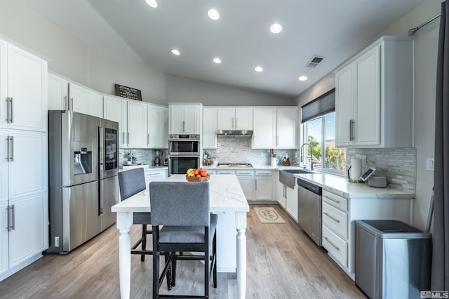 kitchen featuring white cabinets, a center island, stainless steel appliances, and sink