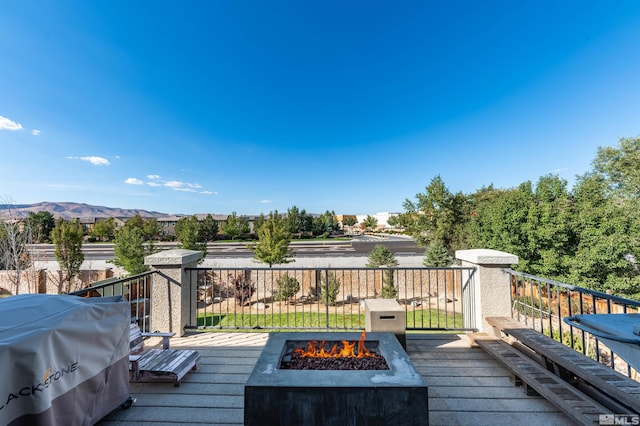 deck featuring a mountain view, an outdoor fire pit, and grilling area