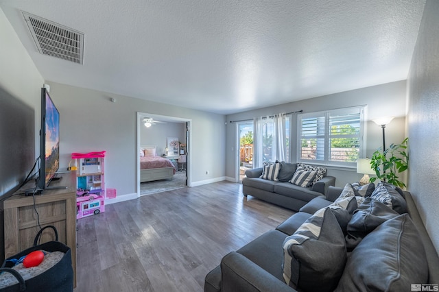 living room with wood-type flooring and a textured ceiling