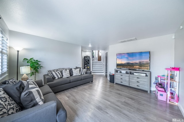 living room featuring wood-type flooring and a textured ceiling