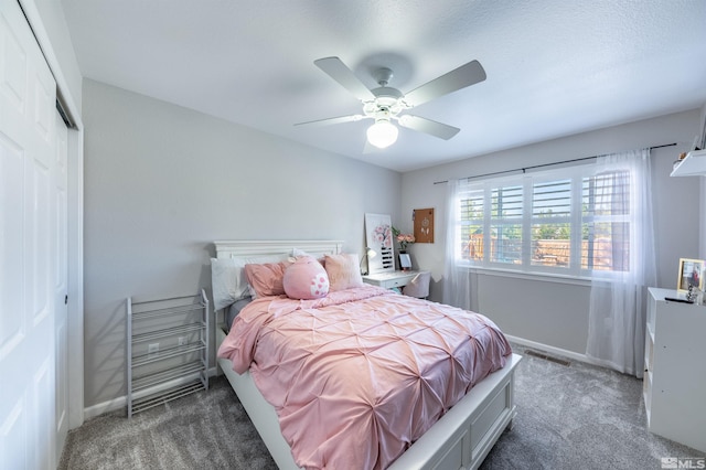 bedroom with dark colored carpet, ceiling fan, and a closet