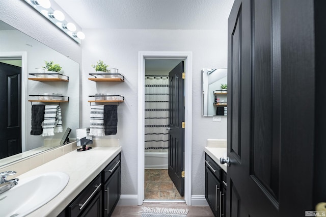 bathroom featuring shower / bath combination with curtain, a textured ceiling, and vanity