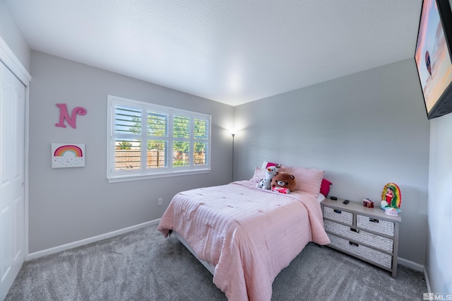 bedroom featuring dark colored carpet and a closet