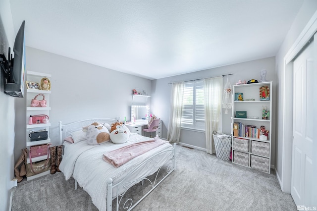 bedroom featuring light carpet and a closet