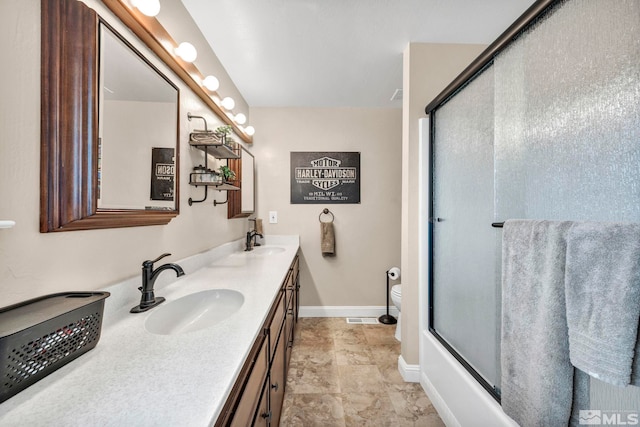 full bathroom with vanity, toilet, and bath / shower combo with glass door