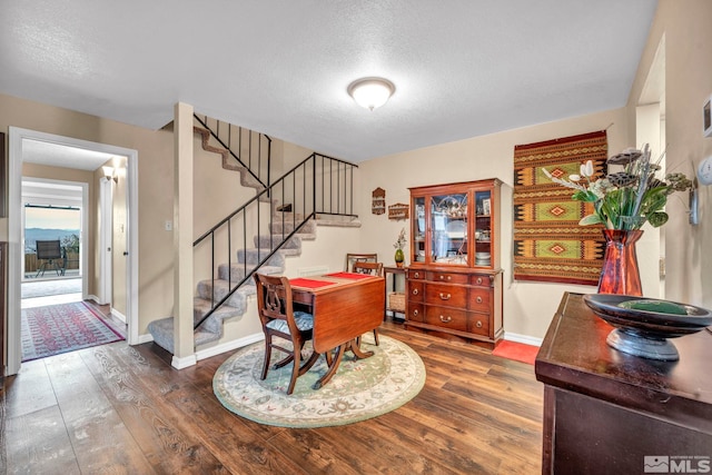 dining room with dark hardwood / wood-style flooring and a textured ceiling