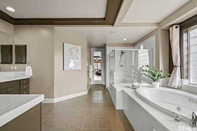 bathroom featuring tile patterned floors, vanity, a healthy amount of sunlight, and plus walk in shower