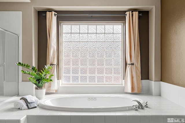 bathroom with shower with separate bathtub and a wealth of natural light