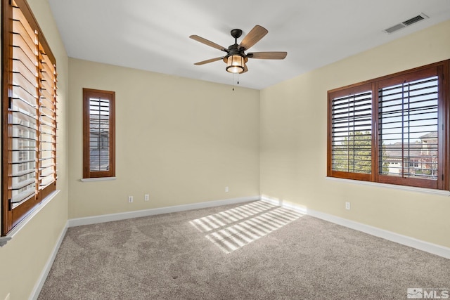 carpeted spare room with ceiling fan