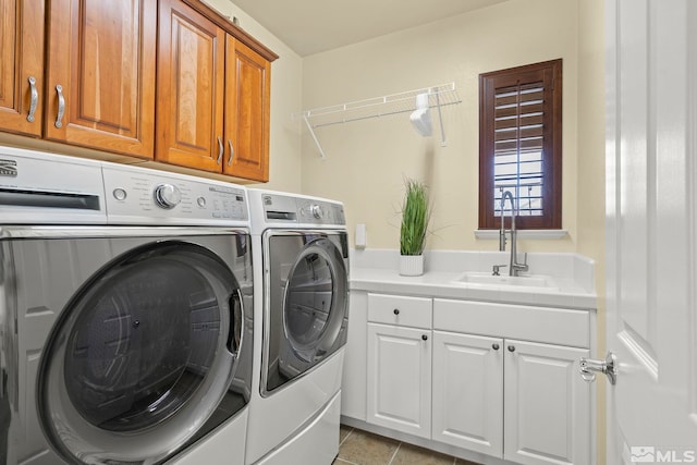 laundry area with light tile patterned flooring, cabinets, independent washer and dryer, and sink