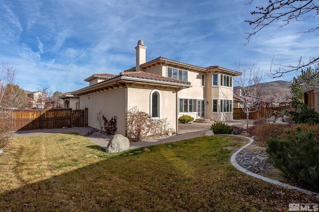 back of house featuring a patio area and a lawn