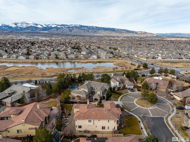 birds eye view of property with a water and mountain view