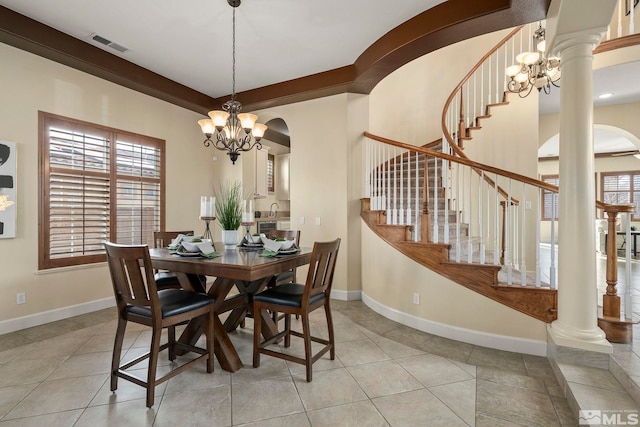 dining area with light tile patterned floors, decorative columns, an inviting chandelier, and sink