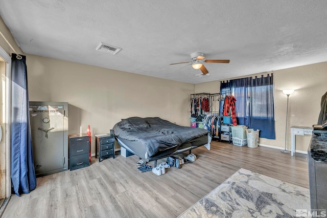 bedroom featuring hardwood / wood-style floors, ceiling fan, and a textured ceiling