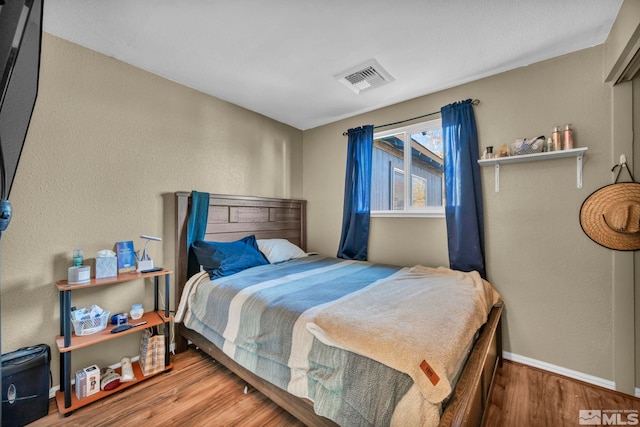 bedroom with hardwood / wood-style flooring