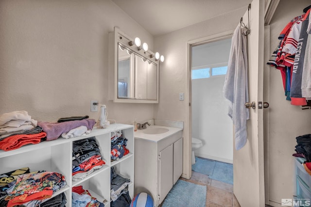 bathroom featuring tile patterned flooring, vanity, and toilet