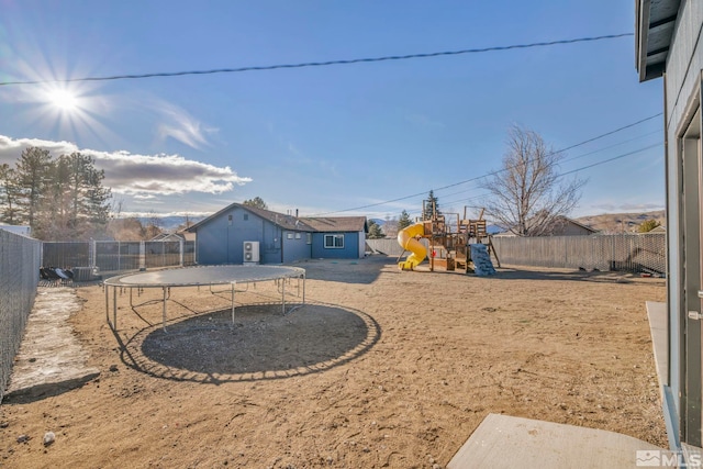 view of yard with a playground and a trampoline