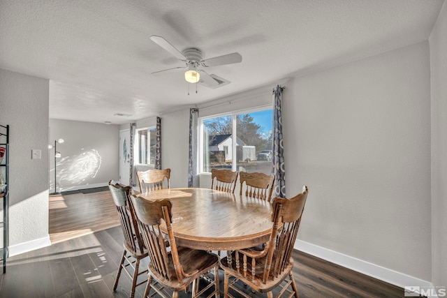 dining area featuring dark hardwood / wood-style floors, ceiling fan, and a textured ceiling