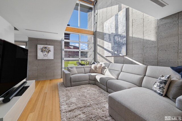 living room with hardwood / wood-style flooring and tile walls