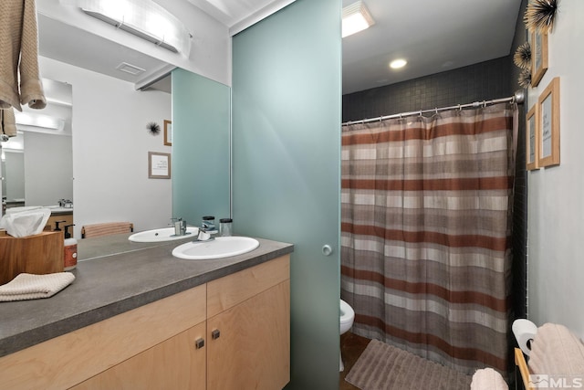 bathroom featuring curtained shower, vanity, and toilet