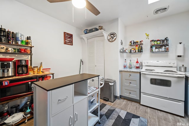 kitchen with gray cabinetry, white electric range oven, ceiling fan, and light wood-type flooring