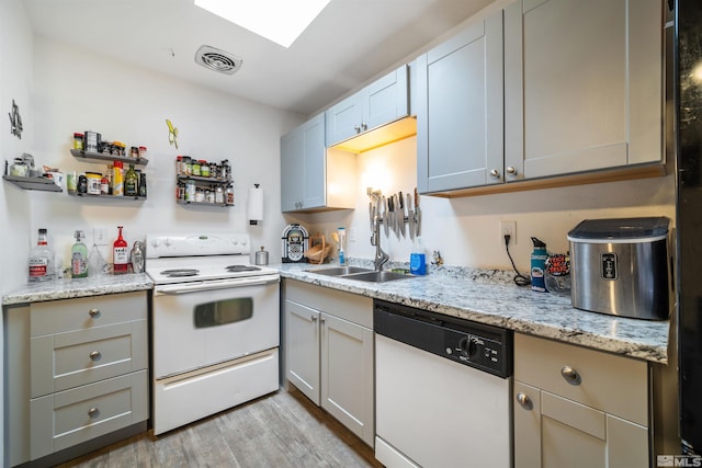 kitchen featuring white appliances, gray cabinets, light hardwood / wood-style flooring, and sink
