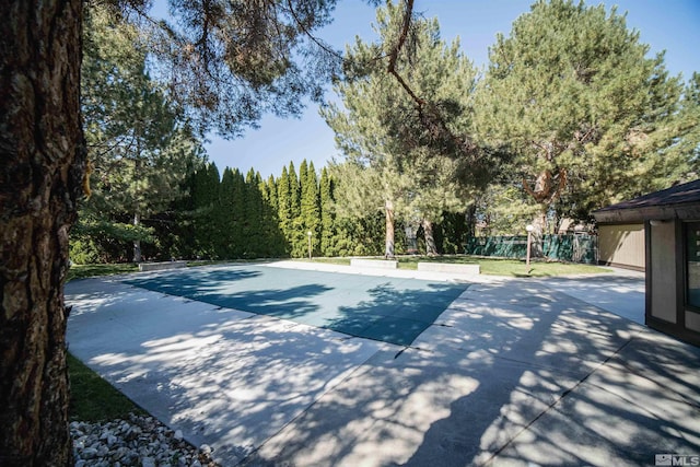 view of sport court featuring a patio area