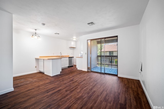 unfurnished living room featuring dark hardwood / wood-style flooring, an inviting chandelier, and sink