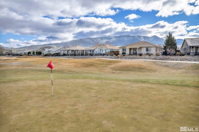 surrounding community with a mountain view and a lawn