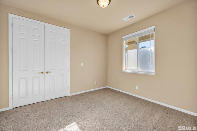 unfurnished bedroom featuring carpet flooring and a closet